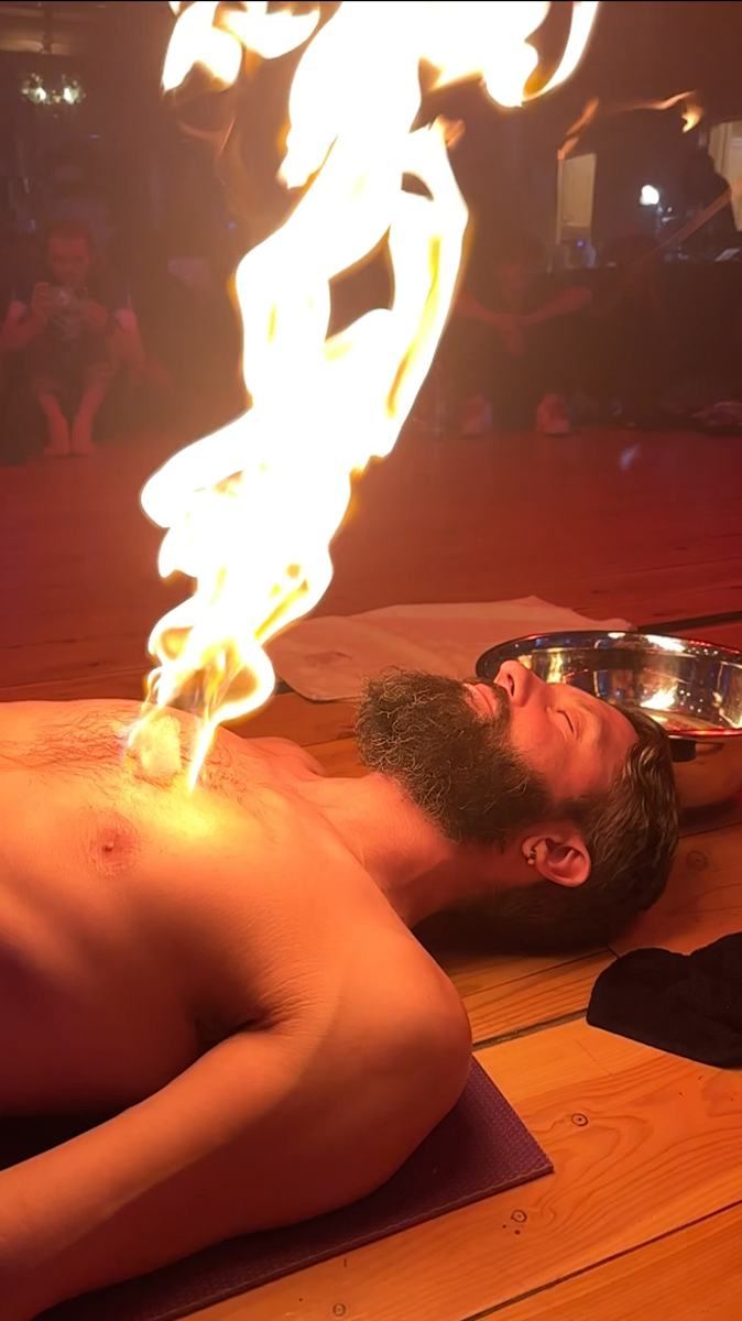 A fire bubble burning on a man's chest as he lies peacefully during a ceremony