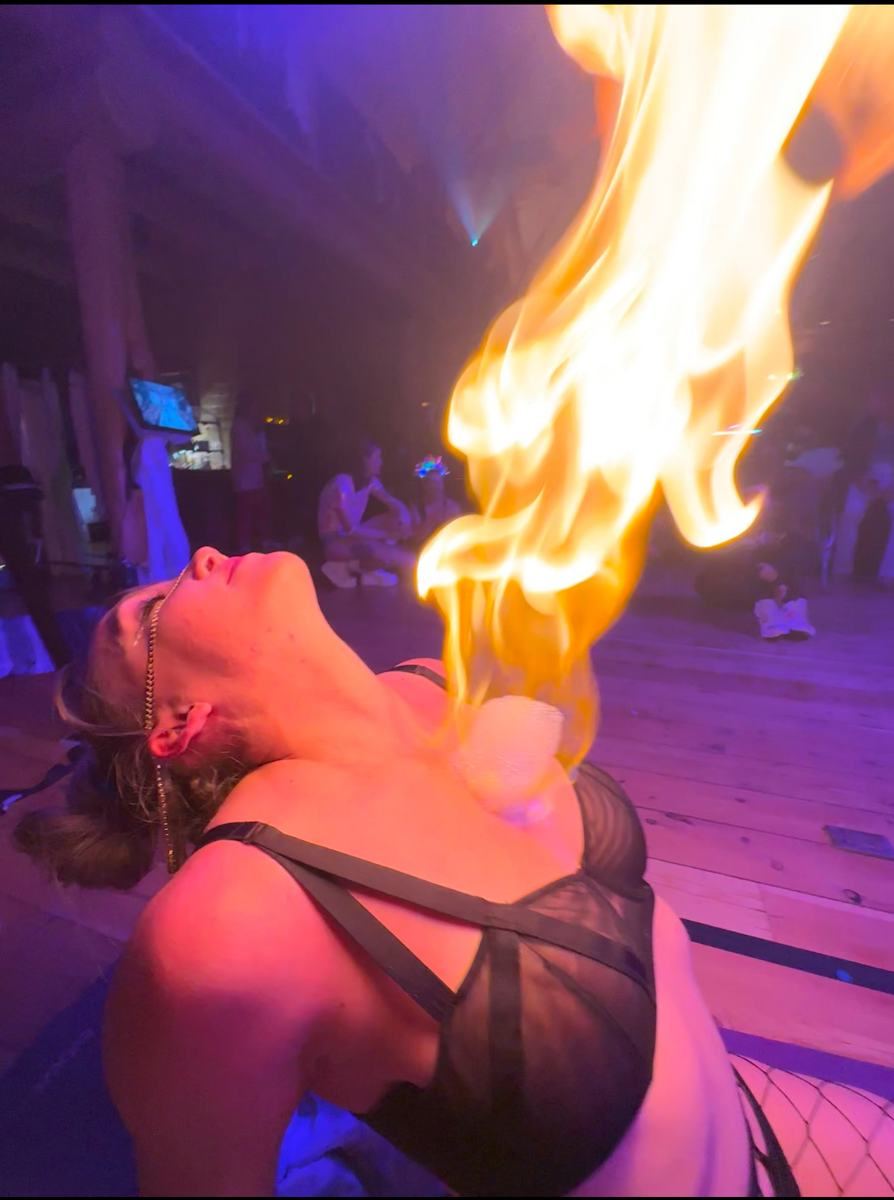 A fire bubble rising from a woman's chest as she leans back in ceremony